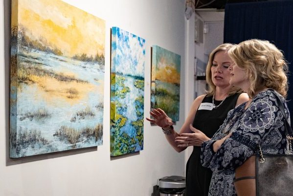 Anne Stein discussing her painting with a patron